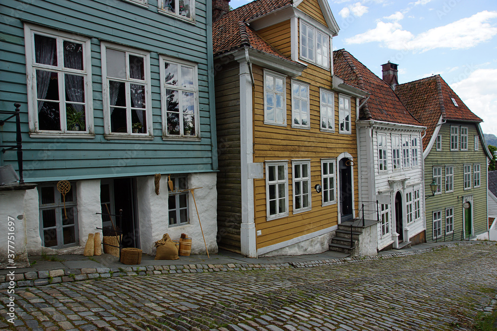 Beautiful multicolored wooden houses stand along the cobblestone street in the city