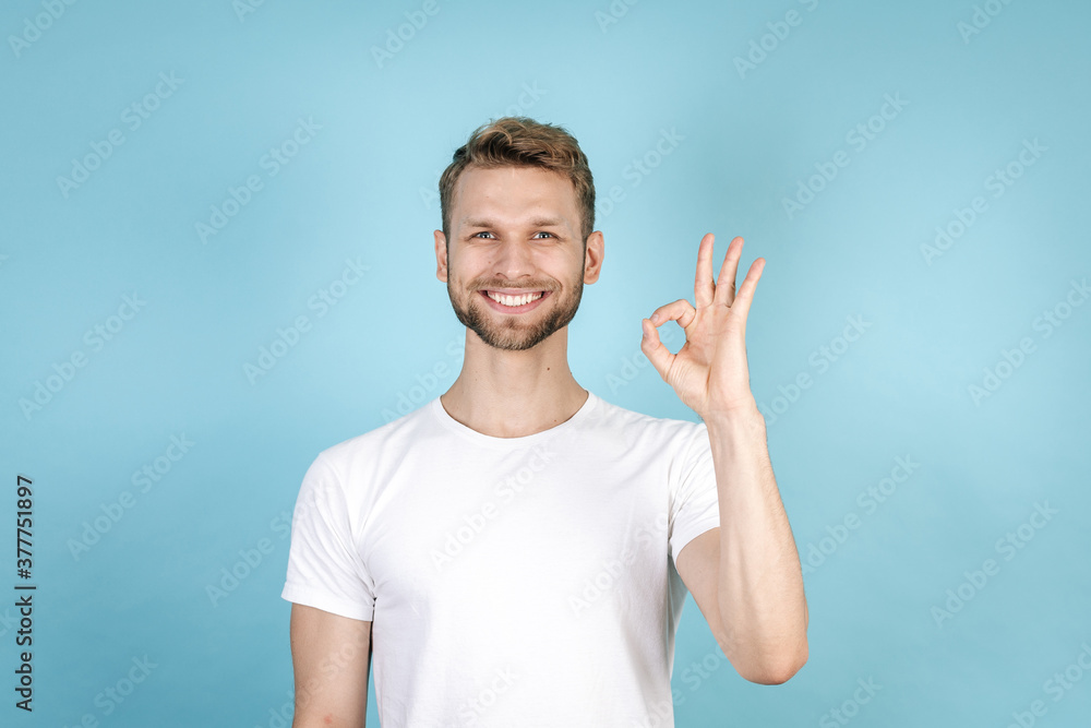 Young man showing ok gesture and smiling wide Young man showing ok gesture and smiling wide