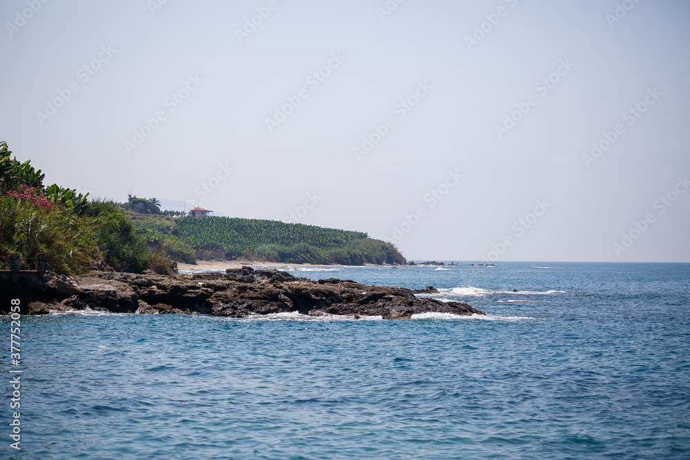 A view of the Mediterranean coast with waves of azure water. Summer seascape. Seaside in sunny weather. Beautiful sea view A view of the Mediterranean coast with waves of azure water. Summer seascape. Seaside in sunny weather. Beautiful sea view