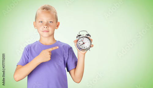 School boy showing alarm clock