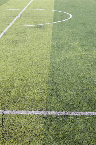 Obraz na płótnie Photo of a green synthetic grass sports field with white line shot from above. w salonie