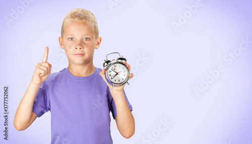 School boy showing alarm clock