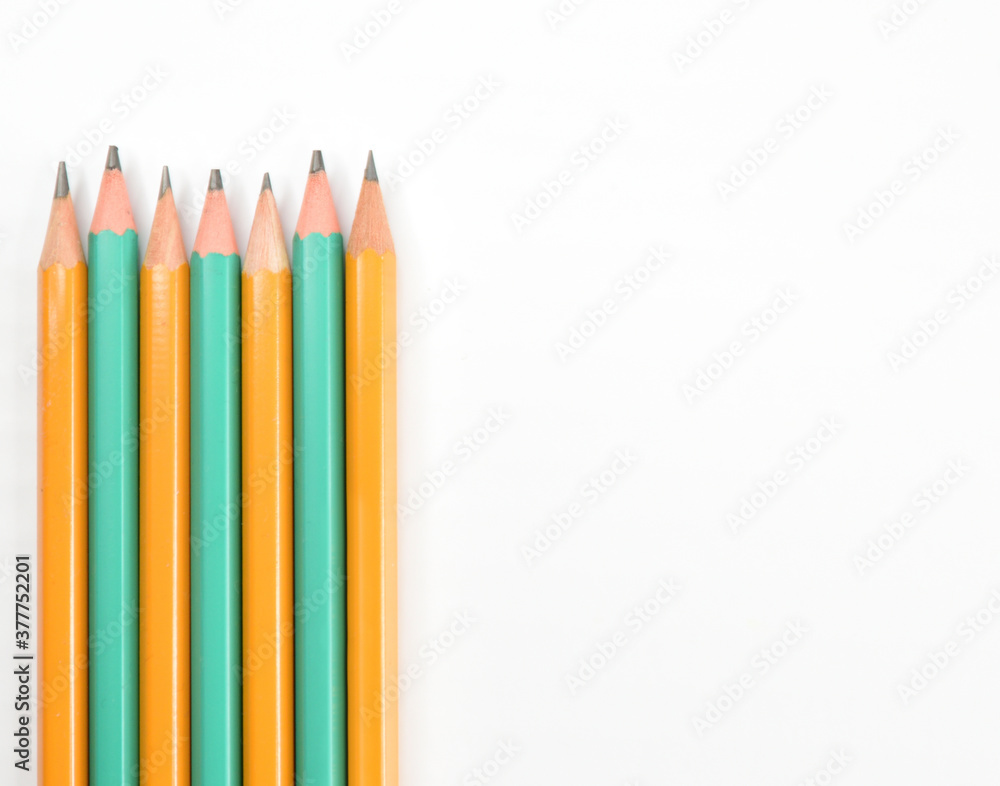 Several simple pencils lying in a row on white paper