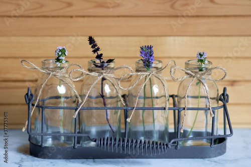 Bottles with herbs in decorative stand wooden beskground
