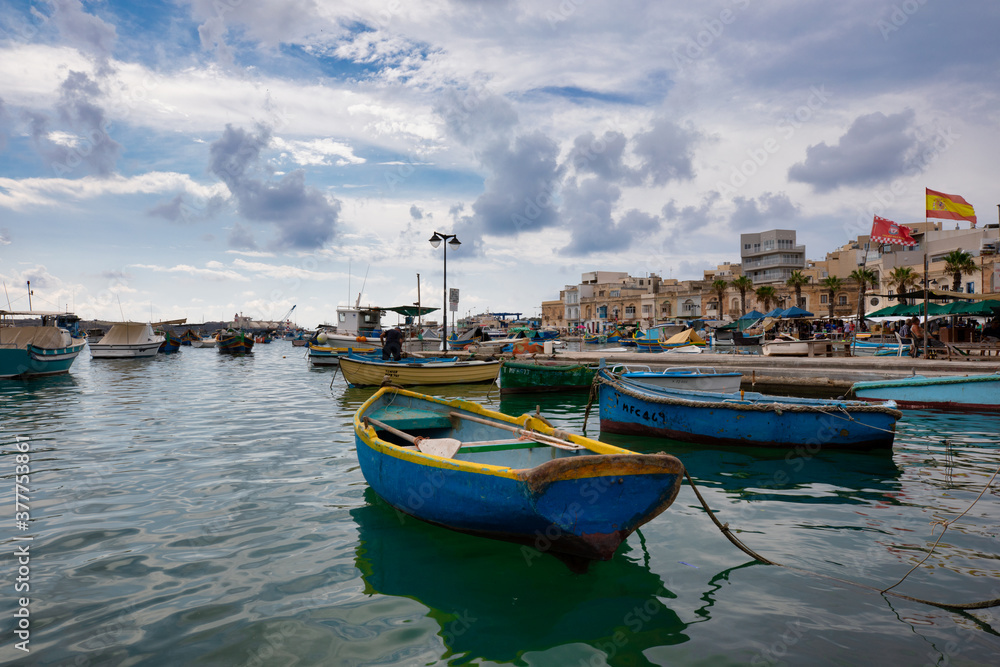 Marsaxlokk, Malta old fisherman village and important tourist attraction on the island. Traditional eyed colorful boats Luzzu in the Harbor of Mediterranean fishing village Marsaxlokk