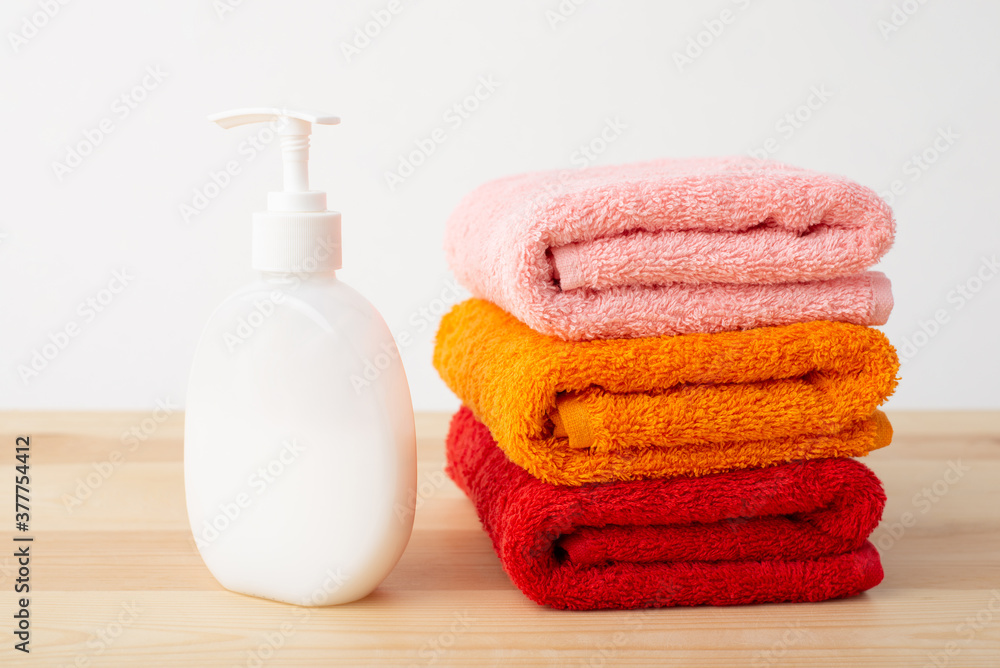 New bright colorful towels and soap on a desk on white background. Hygiene, cleanliness concept. New bright colorful towels and soap on a desk on white background. Hygiene, cleanliness concept.