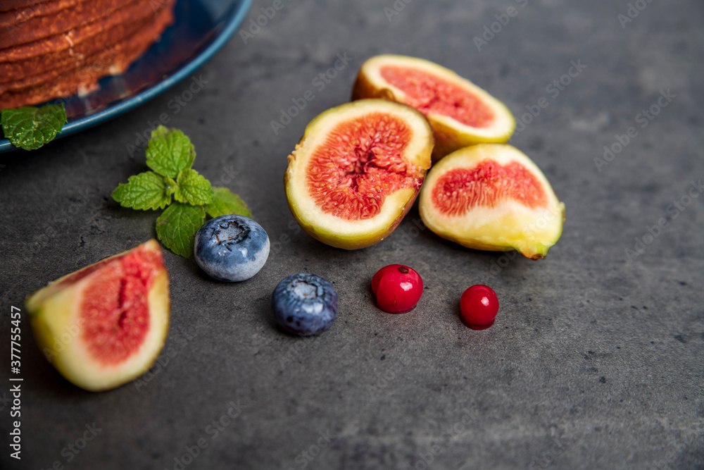 cheesecake in chocolate glaze and figs on dark gray background