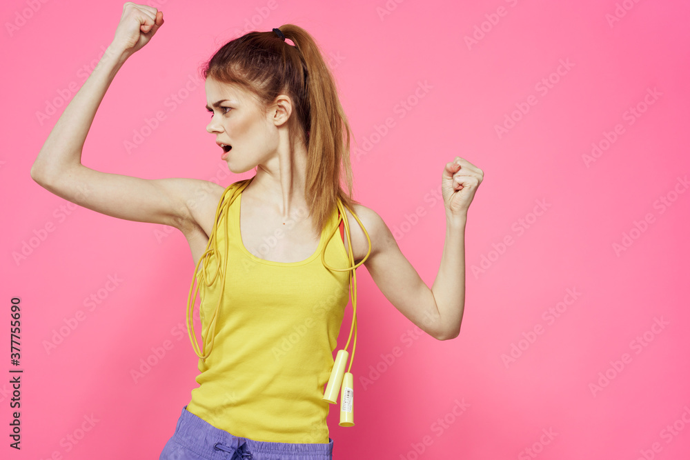 sportive woman jumping rope in hands yellow tank top pink background workout lifestyle sportive woman jumping rope in hands yellow tank top pink background workout lifestyle