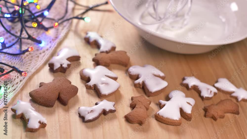Person decorating gingerbread cookies for Christmas. Person decorating gingerbread cookies for Christmas.