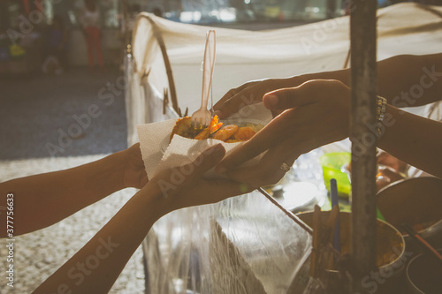person serving vatapa; Brazilian Street food in the streets of Rio de Janeiro, Brazil. Vacation experience exotic food and culture travel destination concept. photo