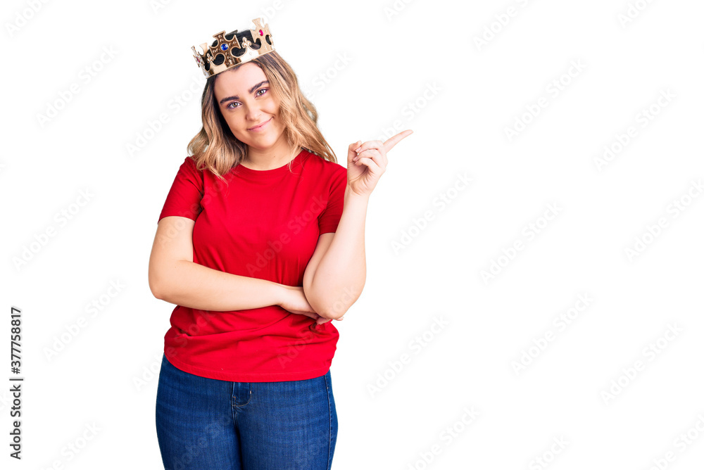 Young caucasian woman wearing princess crown smiling happy pointing with hand and finger to the side Young caucasian woman wearing princess crown smiling happy pointing with hand and finger to the side