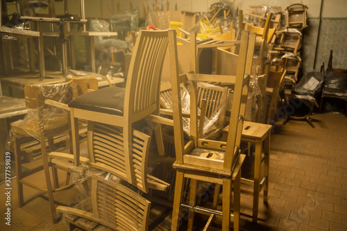 Photo of a furniture warehouse . A mountain of wooden chairs. © Roman