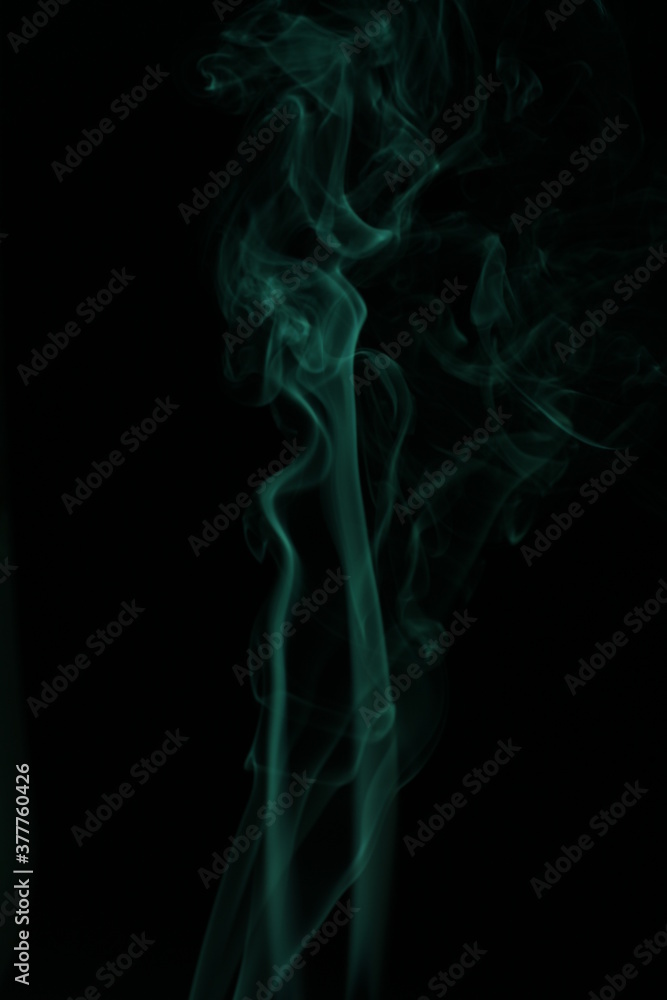 green smoke from incense on a black background green smoke from incense on a black background