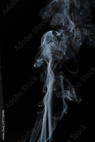 White smoke from incense on a black background