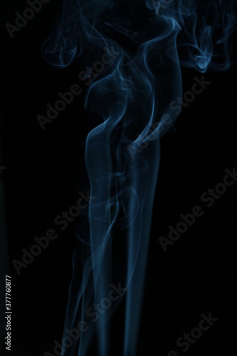 blue smoke from incense on a black background