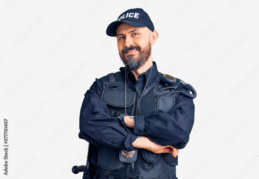 Young handsome man wearing police uniform happy face smiling with crossed arms looking at the camera. positive person. Young handsome man wearing police uniform happy face smiling with crossed arms looking at the camera. positive person.