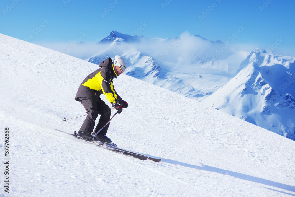 Alpine skier on piste ride downhill