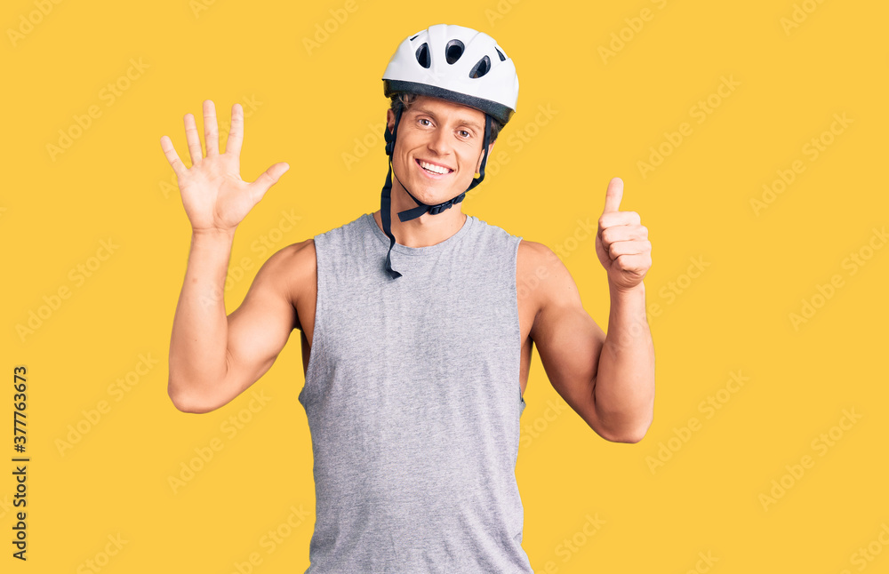 Young handsome man wearing bike helmet showing and pointing up with fingers number six while smiling confident and happy. Young handsome man wearing bike helmet showing and pointing up with fingers number six while smiling confident and happy.