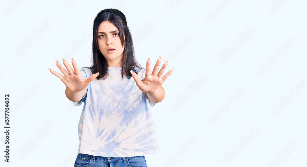 Young beautiful girl wearing casual t shirt doing stop gesture with hands palms, angry and frustration expression Young beautiful girl wearing casual t shirt doing stop gesture with hands palms, angry and frustration expression
