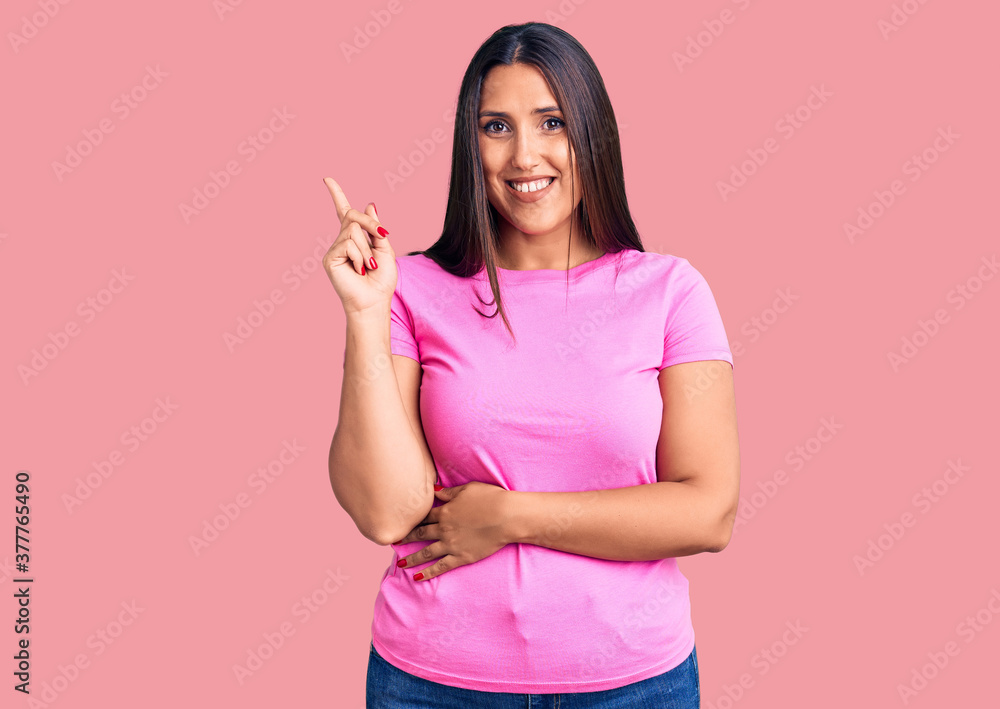 Young beautiful brunette woman wearing casual t-shirt smiling happy pointing with hand and finger to the side Young beautiful brunette woman wearing casual t-shirt smiling happy pointing with hand and finger to the side