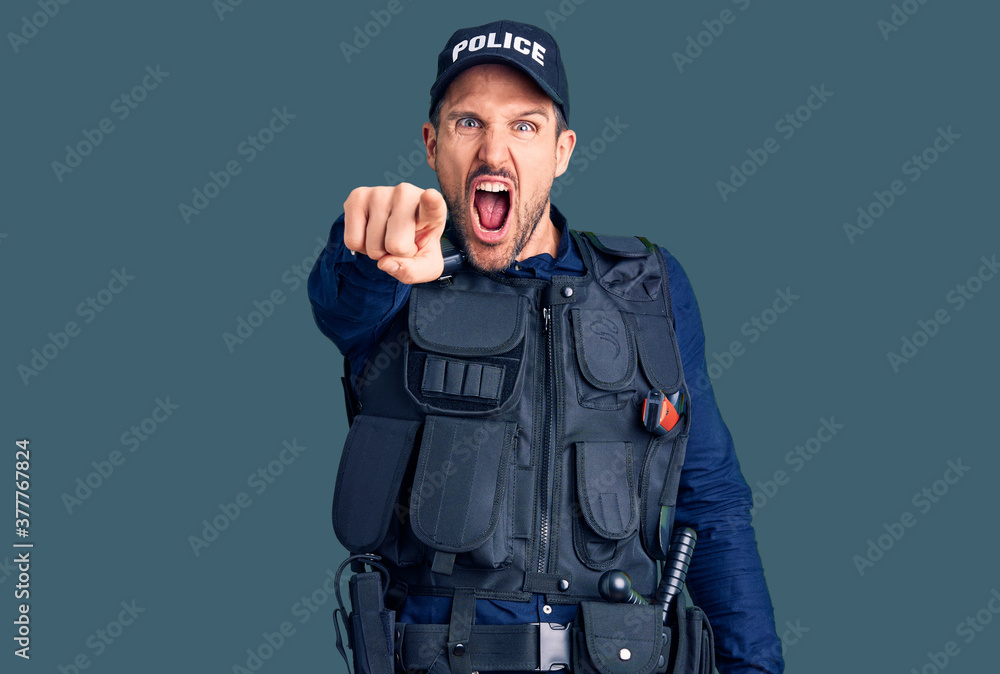 Young handsome man wearing police uniform pointing displeased and frustrated to the camera, angry and furious with you Young handsome man wearing police uniform pointing displeased and frustrated to the camera, angry and furious with you