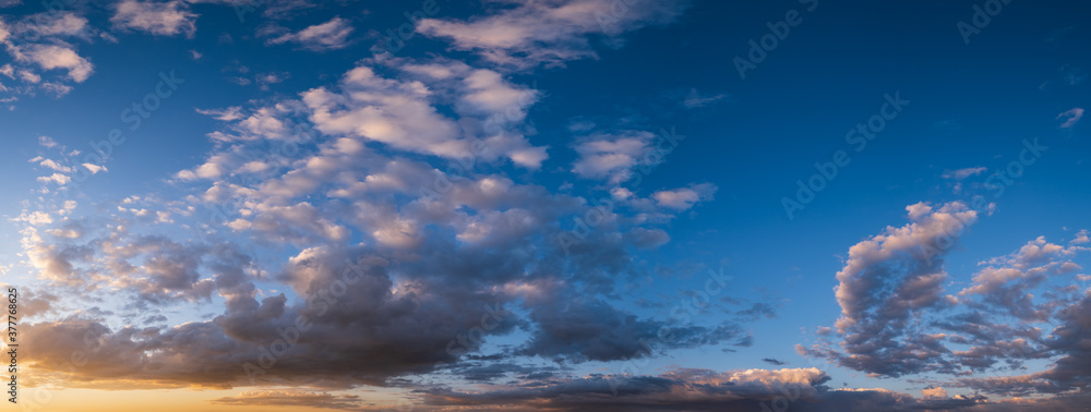 Summer sunset sky panorama with fleece colorful clouds. Evening dusk good weather natural background.