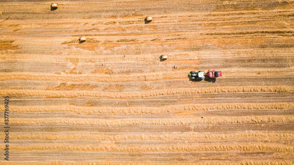 Top view of field with hay sheaves and tractor Top view of field with hay sheaves and tractor