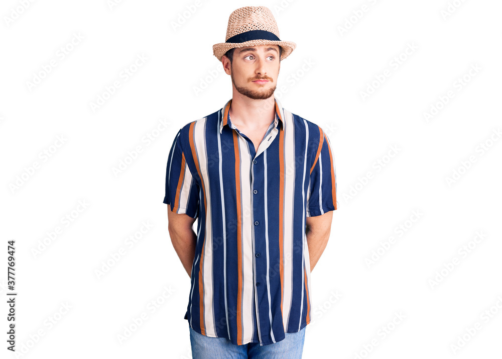 Young handsome caucasian man wearing summer hat smiling looking to the side and staring away thinking. Young handsome caucasian man wearing summer hat smiling looking to the side and staring away thinking.