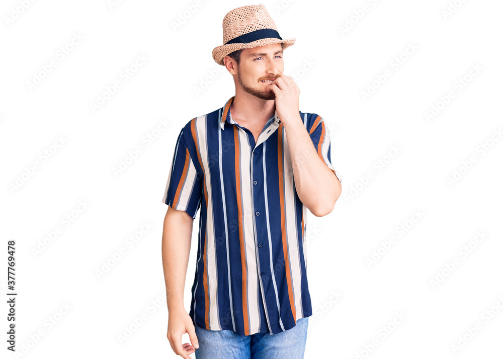Young handsome caucasian man wearing summer hat looking stressed and nervous with hands on mouth biting nails. anxiety problem. Young handsome caucasian man wearing summer hat looking stressed and nervous with hands on mouth biting nails. anxiety problem.