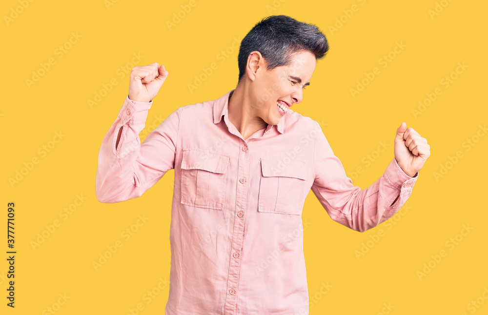 Young woman with short hair wearing casual clothes dancing happy and cheerful, smiling moving casual and confident listening to music Young woman with short hair wearing casual clothes dancing happy and cheerful, smiling moving casual and confident listening to music