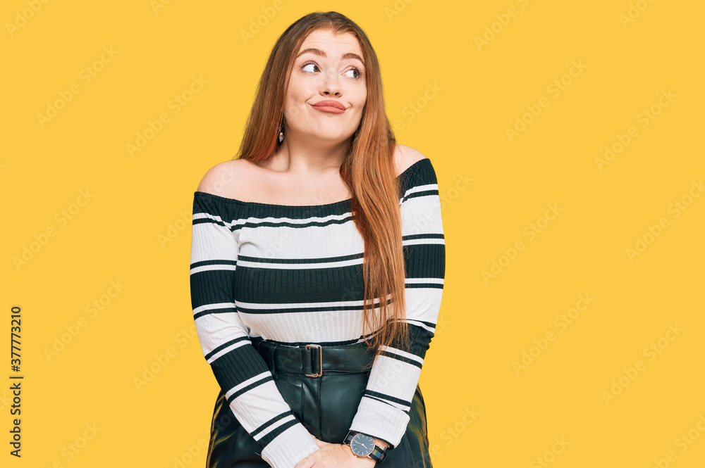 Young beautiful redhead woman wearing elegant clothes smiling looking to the side and staring away thinking. Young beautiful redhead woman wearing elegant clothes smiling looking to the side and staring away thinking.