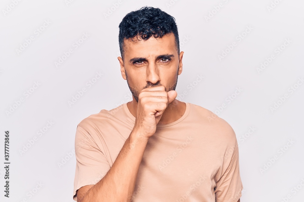 Young hispanic man wearing casual clothes feeling unwell and coughing as symptom for cold or bronchitis. health care concept. Young hispanic man wearing casual clothes feeling unwell and coughing as symptom for cold or bronchitis. health care concept.