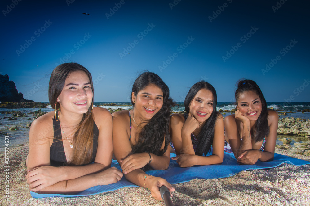 Multi ethnic group girls friends enjoy summer using tecnology to selfie photo at caribbean beach in Los Roques Venezuela Multi ethnic group girls friends enjoy summer using tecnology to selfie photo at caribbean beach in Los Roques Venezuela