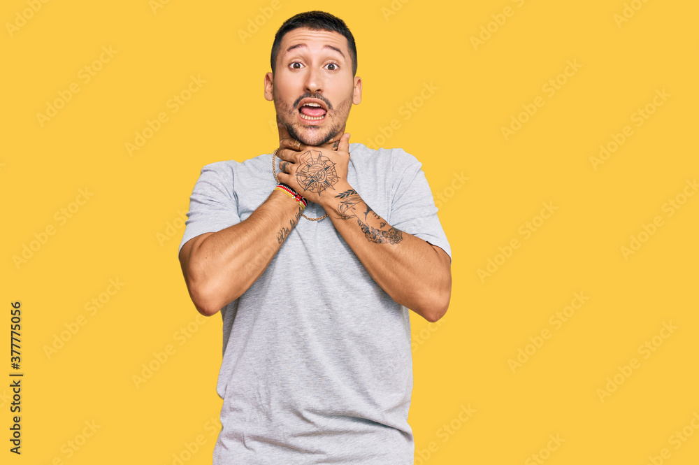 Handsome man with tattoos wearing 90s style shouting and suffocate because painful strangle. health problem. asphyxiate and suicide concept. Handsome man with tattoos wearing 90s style shouting and suffocate because painful strangle. health problem. asphyxiate and suicide concept.