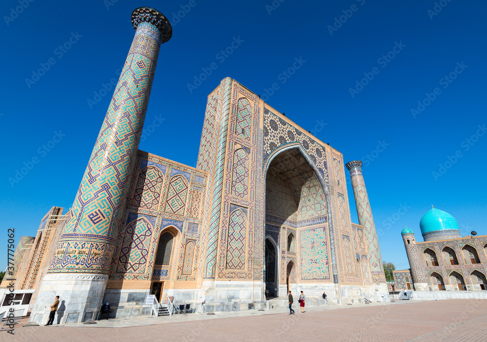 Ulugh Beg Madrasah (Islamic school) and its two minarets with ceramic tiles in Persian style. Registan, Samarkand, Uzbekistan.