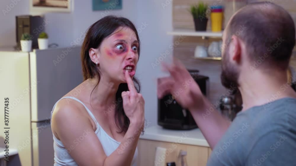 Traumatised woman yelling at drunk man holding a bottle of wine. Abused terrified beaten wife covered in bruises suffering injury from alcoholic violent brutal aggressive husband screeming, fighting. Traumatised woman yelling at drunk man holding a bottle of wine. Abused terrified beaten wife covered in bruises suffering injury from alcoholic violent brutal aggressive husband screeming, fighting.