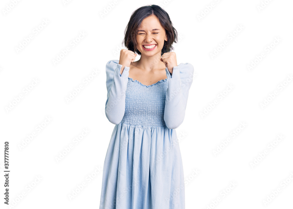 Young beautiful girl wearing casual clothes excited for success with arms raised and eyes closed celebrating victory smiling. winner concept. Young beautiful girl wearing casual clothes excited for success with arms raised and eyes closed celebrating victory smiling. winner concept.