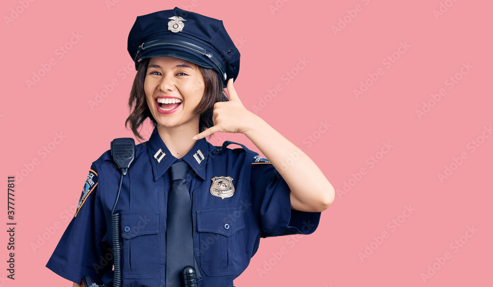 Young beautiful girl wearing police uniform smiling doing phone gesture with hand and fingers like talking on the telephone. communicating concepts. Young beautiful girl wearing police uniform smiling doing phone gesture with hand and fingers like talking on the telephone. communicating concepts.