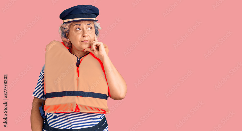Senior woman with gray hair wearing nautical lifejacket serious face thinking about question with hand on chin, thoughtful about confusing idea Senior woman with gray hair wearing nautical lifejacket serious face thinking about question with hand on chin, thoughtful about confusing idea