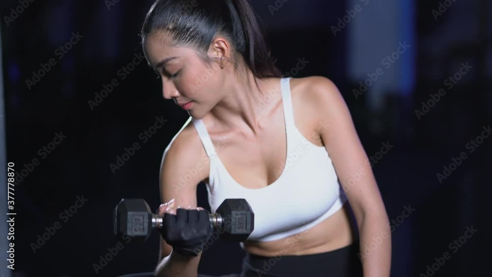 Asia beautiful sport woman exercising with dumbbell in fitness gym 4K resolution Asia beautiful sport woman exercising with dumbbell in fitness gym 4K resolution