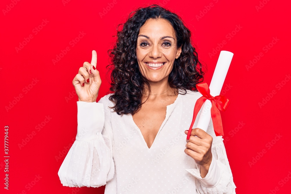 Middle age beautiful woman holding graduate degree diploma smiling with an idea or question pointing finger with happy face, number one Middle age beautiful woman holding graduate degree diploma smiling with an idea or question pointing finger with happy face, number one