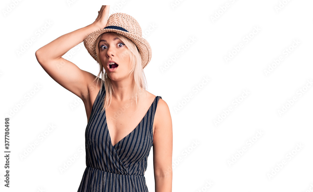 Young beautiful blonde woman wearing summer hat and dress surprised with hand on head for mistake, remember error. forgot, bad memory concept. Young beautiful blonde woman wearing summer hat and dress surprised with hand on head for mistake, remember error. forgot, bad memory concept.