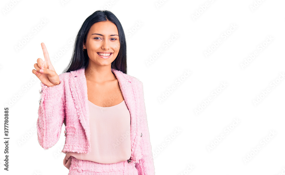 Young beautiful latin girl wearing business clothes pointing finger up with successful idea. exited and happy. number one. Young beautiful latin girl wearing business clothes pointing finger up with successful idea. exited and happy. number one.
