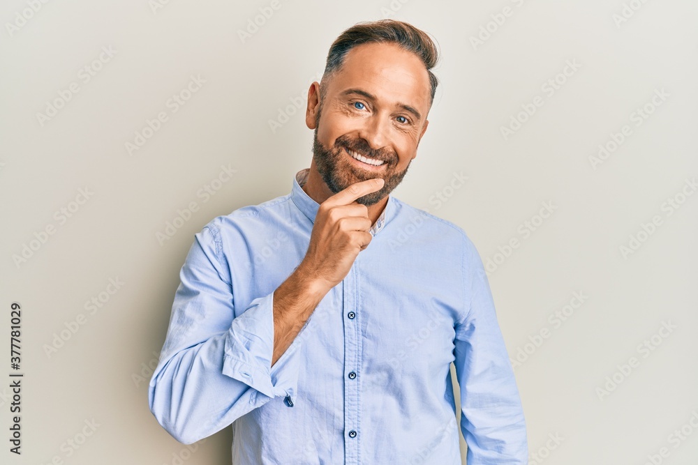 Handsome middle age man wearing business clothes smiling looking confident at the camera with crossed arms and hand on chin. thinking positive. Handsome middle age man wearing business clothes smiling looking confident at the camera with crossed arms and hand on chin. thinking positive.