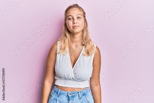 Young blonde girl wearing casual clothes relaxed with serious expression on face. simple and natural looking at the camera.