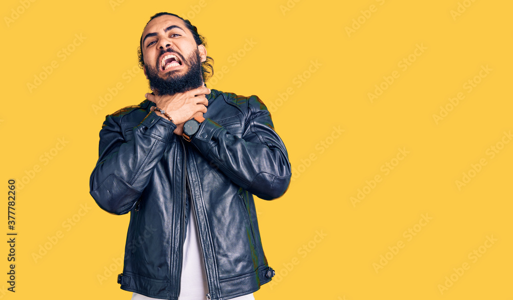 Young arab man wearing casual leather jacket shouting suffocate because painful strangle. health problem. asphyxiate and suicide concept. Young arab man wearing casual leather jacket shouting suffocate because painful strangle. health problem. asphyxiate and suicide concept.