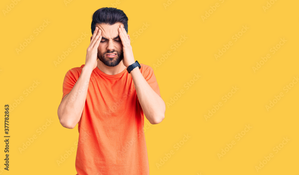 Young handsome man with beard wearing casual t-shirt with hand on head, headache because stress. suffering migraine. Young handsome man with beard wearing casual t-shirt with hand on head, headache because stress. suffering migraine.