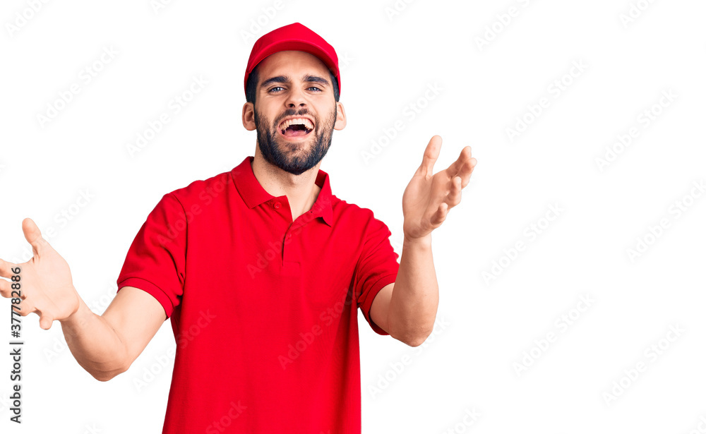 Young handsome man with beard wearing delivery uniform smiling cheerful offering hands giving assistance and acceptance. Young handsome man with beard wearing delivery uniform smiling cheerful offering hands giving assistance and acceptance.