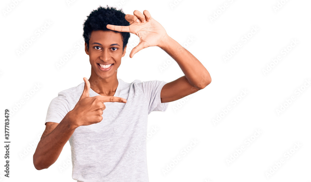 Young african american man wearing casual white t shirt smiling making frame with hands and fingers with happy face. creativity and photography concept. Young african american man wearing casual white t shirt smiling making frame with hands and fingers with happy face. creativity and photography concept.