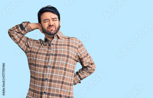 Young hispanic man wearing casual clothes suffering of neck ache injury, touching neck with hand, muscular pain